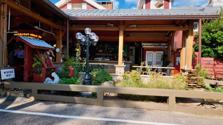 Covered wooden patio with a lamppost, planters and a small red kiosk at the Angus Barn