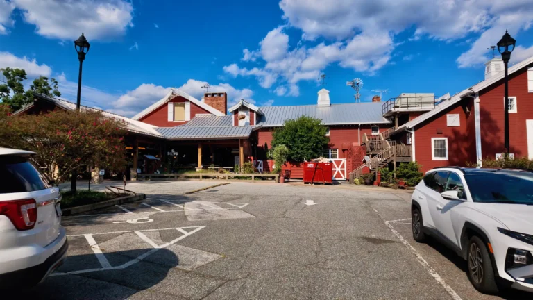 Red barn-style restaurant buildings with metal roofs across a parking lot