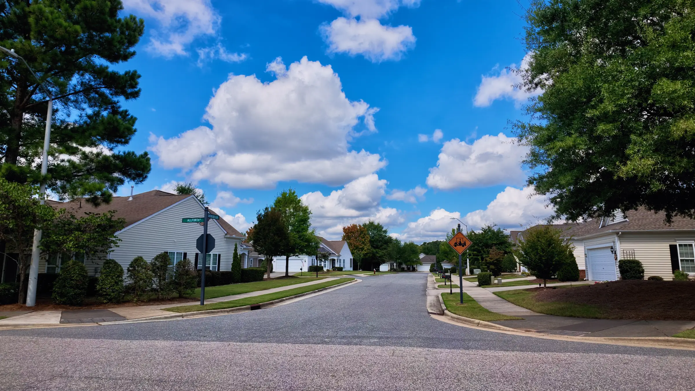 Quiet intersection in Carolina Preserve with single-story homes, a stop sign and mature trees